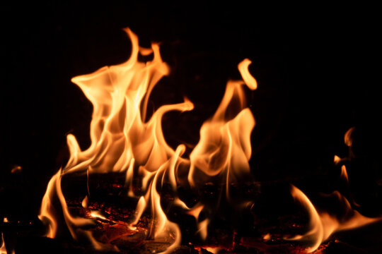 Flammes flamboyantes d'un feu de bois en premier plan, arri&egrave;re plan noir
