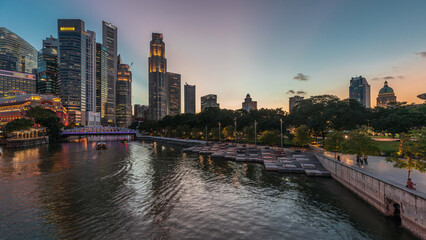 Obraz premium Singapore skyscrapers skyline with white Anderson Bridge near esplanade park day to night timelapse.