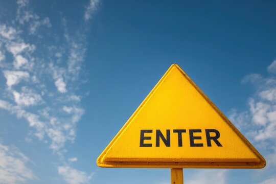 A yellow triangular sign reading ENTER against a blue sky with wispy clouds