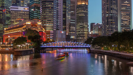 Naklejka premium Singapore skyscrapers skyline with white Anderson Bridge near esplanade park day to night timelapse.