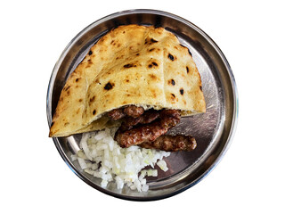 Delicious flatbread with grilled meat served on a metal plate with chopped onions