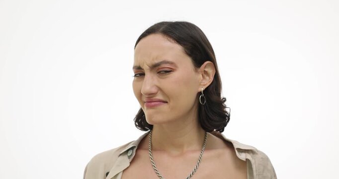 Woman covers mouth and nose with hand expressing disgust on white background. Dissatisfied female shows displeasure with smell and view. Slow motion