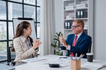 Diverse business colleagues clapping and smiling during a successful meeting, celebrating a team achievement and expressing appreciation in a corporate office environment