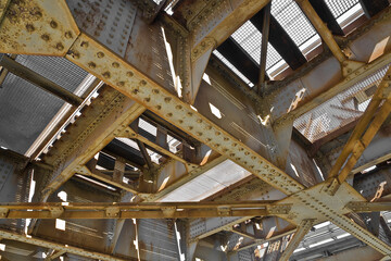 OLD WEATHERED AND PARTIALLY RUSTED STEEL TRUSS BEAM STRUCTURE with connection plates and bolts in poor condition - The damaged structure requires maintenance