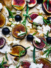 Delicious fig and cheese pizza topped with herbs and nuts served fresh