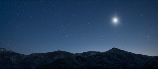a Christmas star shines at night over the mountains of Bethlehem