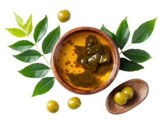 Overhead shot of a wooden bowl with marinated green peppers and olives with leaves