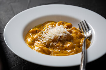 Gnocchi in pumpkin sauce with Parmesan cheese