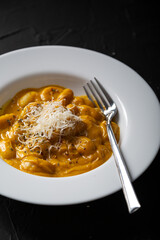Gnocchi in pumpkin sauce with Parmesan cheese