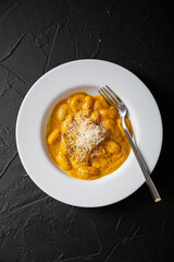 Gnocchi in pumpkin sauce with Parmesan cheese