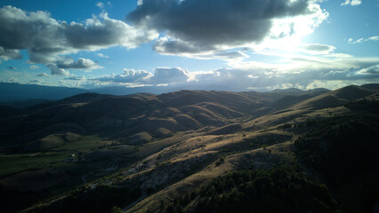 Fototapeta premium Drone aerial view of Castel del Monte, Abruzzo, a medieval hilltop village with ancient stone architecture and panoramic landscapes
