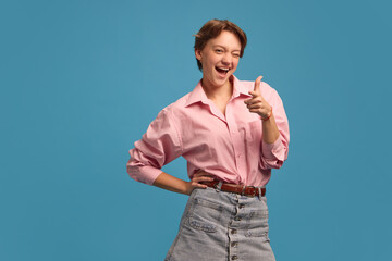 Winking woman pointing finger with confident playful expression. Concept of charm, self-confidence,...