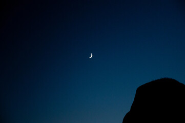 Crescent moon glowing in vibrant night sky