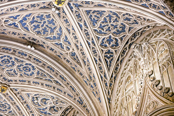 Intricately carved Gothic ceiling with blue and gold detailing inside the Abbaye d’Hautecombe, showcasing masterful stone craftsmanship and sacred architectural beauty