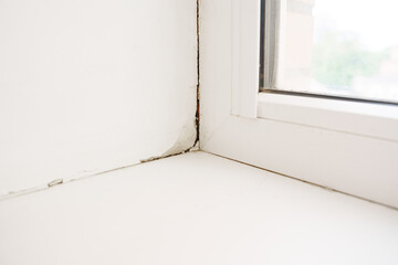 Inspection of a window corner showing paint wear and slight damage