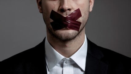 Powerful businessman silenced and censored with tape over mouth in protest against injustice and oppression