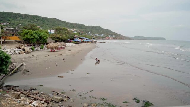 Panoramic view of a person on the wet sand of a beach in puerto colombia