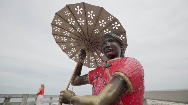 Sculpture honoring chinese immigrants on the famous pier of puerto colombia, a historic landmark