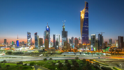 Fototapeta premium Skyline with Skyscrapers day to night timelapse in Kuwait City downtown illuminated at dusk. Kuwait City, Middle East