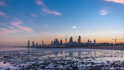 Seaside skyline of Kuwait city from night to day timelapse