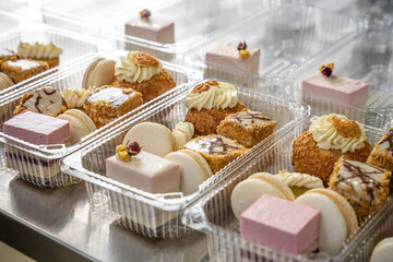 Assorted gourmet desserts in takeaway plastic boxes