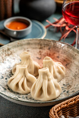 Traditional Georgian khinkali dumplings with sauce and red wine