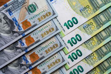 Background of 100 dollars cash and 100 euro bills, top view, closeup. Cash banknotes, financial money concept. American and European currency