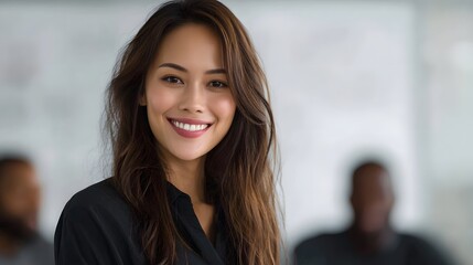 Fototapeta premium A smiling professional woman looks confidently at the in a bright office setting