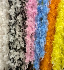 Fondo con gran variedad de boas de plumas de colores a la venta en comercio 