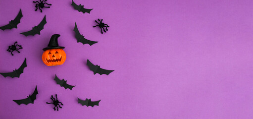 Halloween composition with Jack-o-lantern and black bats on purp