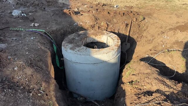 Installation of new septic tank made of precast concrete rings. Sewage system on the site