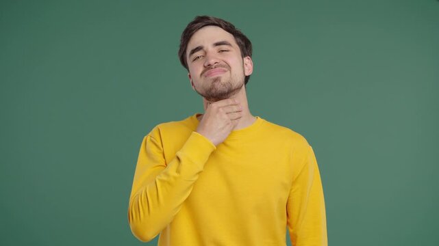 Young Man Has Sore. Sick Guy With Swollen Throat On Green Studio. Angina, Pain 