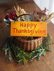 Thanksgiving Basket with Dried Flowers and Festive Sign on Wooden Surface