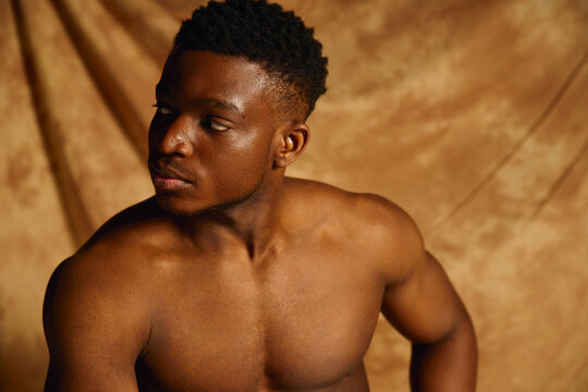 Muscular african american man poses confidently in a studio setting