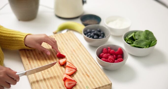 Person, hands and cutting with strawberries for diet, smoothie or healthy meal prep in kitchen. Nutritionist, ingredients and chopping board with natural organic fruit or blender for vitamins in home