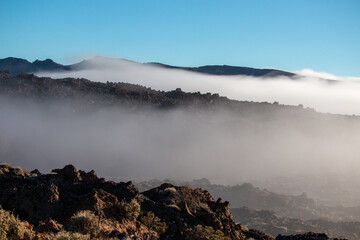 Ethereal Mist Blankets a Rugged Volcanic Landscape Under a Clear Morning Sky
