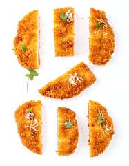 Slices of breaded, golden-brown food, arranged artfully on a white background.  Small,  fresh greens adorn each piece