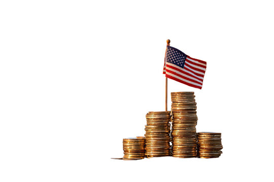 A miniature American flag proudly stands atop stacked coins, symbolizing economic growth and prosperity