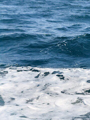 waves on the beach, Close-up view of sea surface with white foam, creating a natural abstract background suitable for design, relaxation, or environmental concepts.