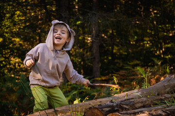 Little boy enjoys a walk in the forest and has fun
