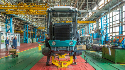 Conveyor assembly stage the body of tractor at big industrial factory timelapse