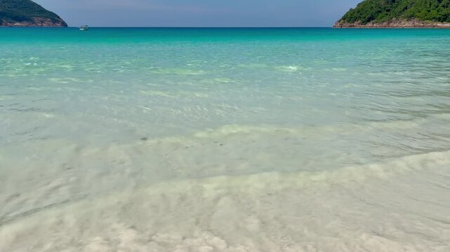 Beautiful beach with white sand abd turquoise water waves are running