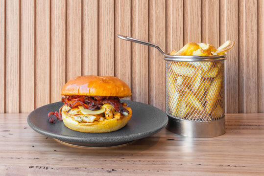 Classic burger with a double patty of beef, soft yellow brioche bun, accompanied by pickles and crispy onion rings