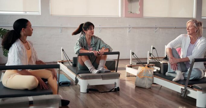 Reformer pilates, women or talking in studio for fitness, exercise or workout tips for healthy body. Active, people and group in gym with conversation, discussion or communication for wellness goals.
