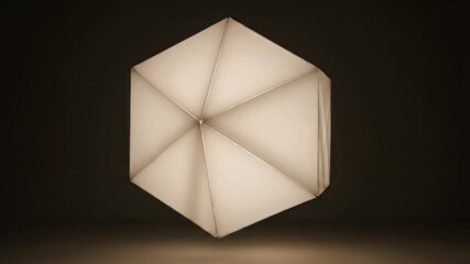 A mesmerizing abstract video showcases a geometric, multifaceted light sculpture slowly rotating in a dark void. The intricate polyhedron design glows ethereally, subtly transitioning its luminous col - Powered by Adobe