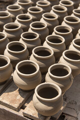 Clay pots are being dried in the sunlight. crafted by a potter. traditional earthenware making, preparation before storage or further processing.