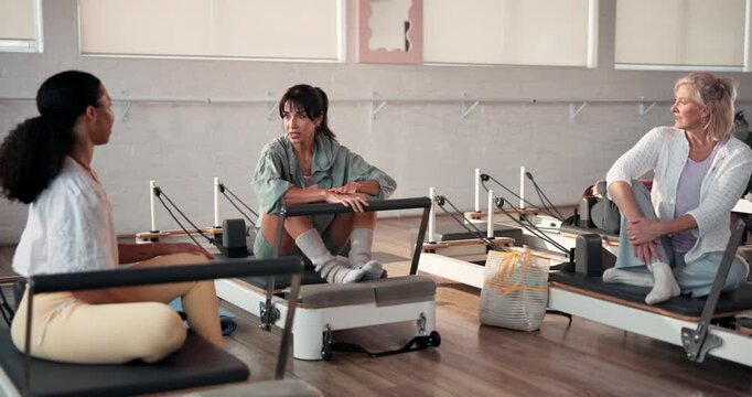 Reformer pilates, women or conversation in studio for fitness, exercise or workout tips for healthy body. Active, people and group in gym with discussion, communication or talking for wellness goals.
