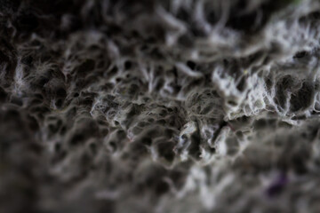 Extreme close up of old gray handmade paper clay with a structure and rough texture. Paper recycling. Selective soft focus, shallow depth of field.