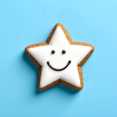 Smiling Star-Shaped Cookie with White Icing on Blue Background