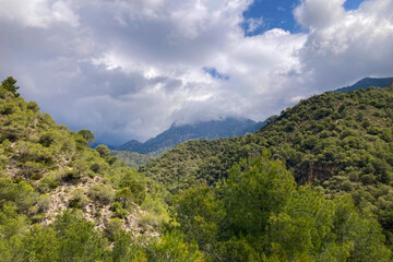 Scenic view of surrounding mountains and picturesque village from a hiking trail along an old irrigation ditch in Frigiliana, Spain.